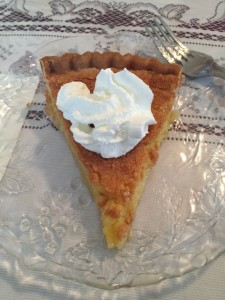 Chess pie served warm with a dollop of whipped cream.