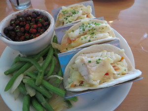 Mahi mahi grilled tacos on pineapple slaw with fresh green beans and sauteed onions and black beans with spices and lime juice.