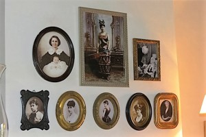 A wall of portraits mostly feature Laura Locoul Gore.