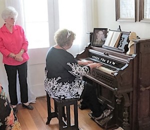 Sylvia Zeringue watching as I tried my hand at playing the pump organ.