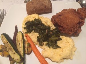 Geechie Boy Grits with Greens on top, fried chicken, and roasted veggies.