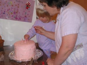 Allie and Grandmomma getting a pink birthday cake ready for her 3rd birthday party.