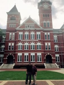 Samford Hall with 2 old grads in front.